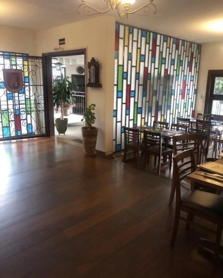 Parede de vitral colorido e piso de madeira no salão