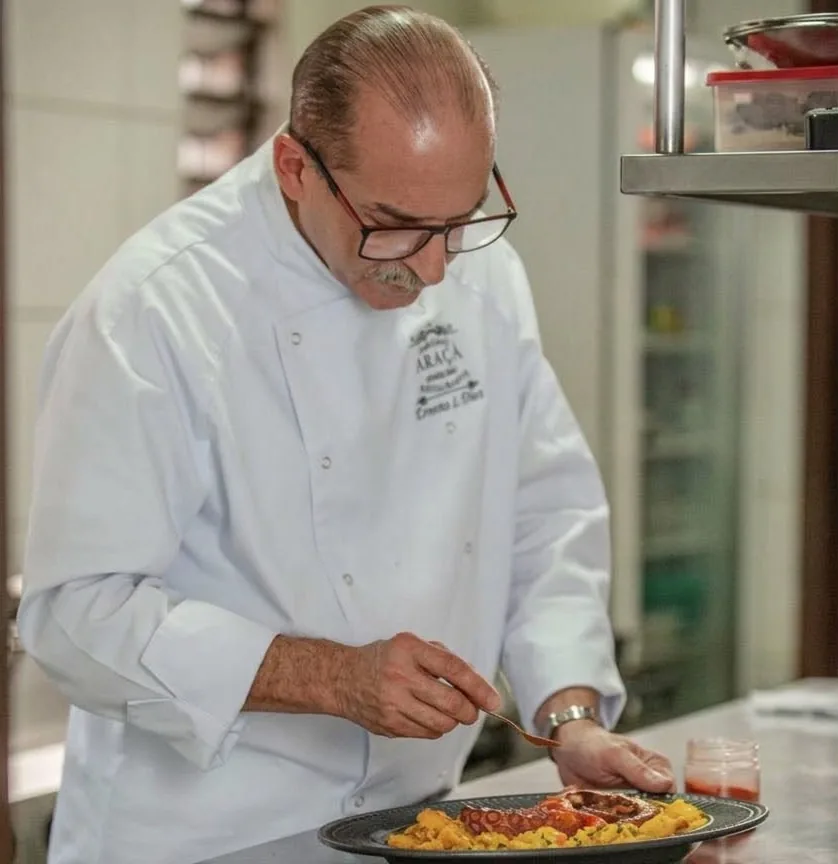 Chef Ernesto L. Diez finalizando um prato de polvo na cozinha do Empório Araçá