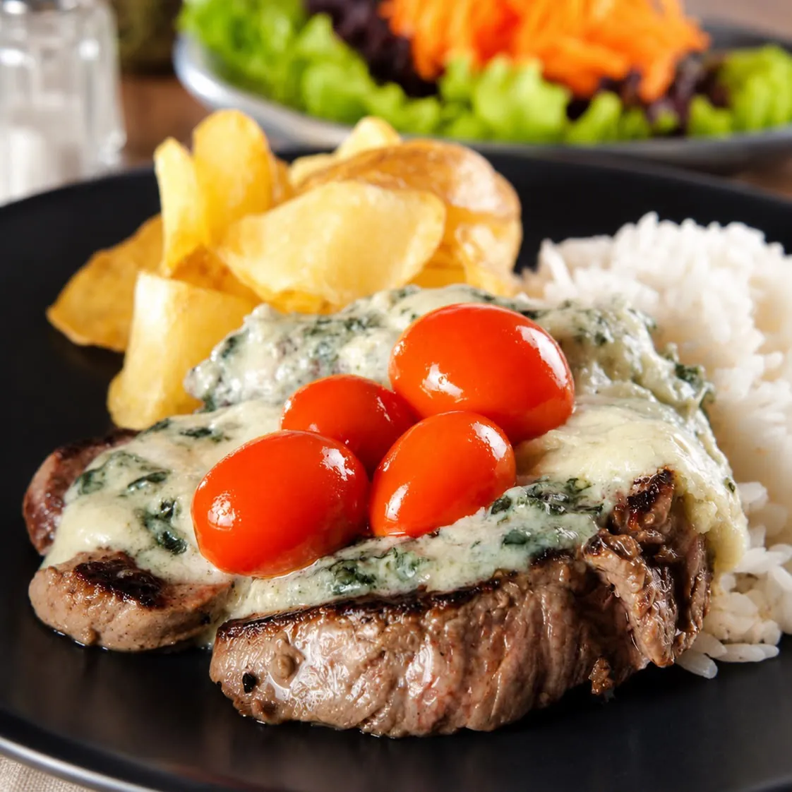 Medalhão de mignon com molho de gorgonzola e tomates-cereja, acompanhado de batatas e arroz